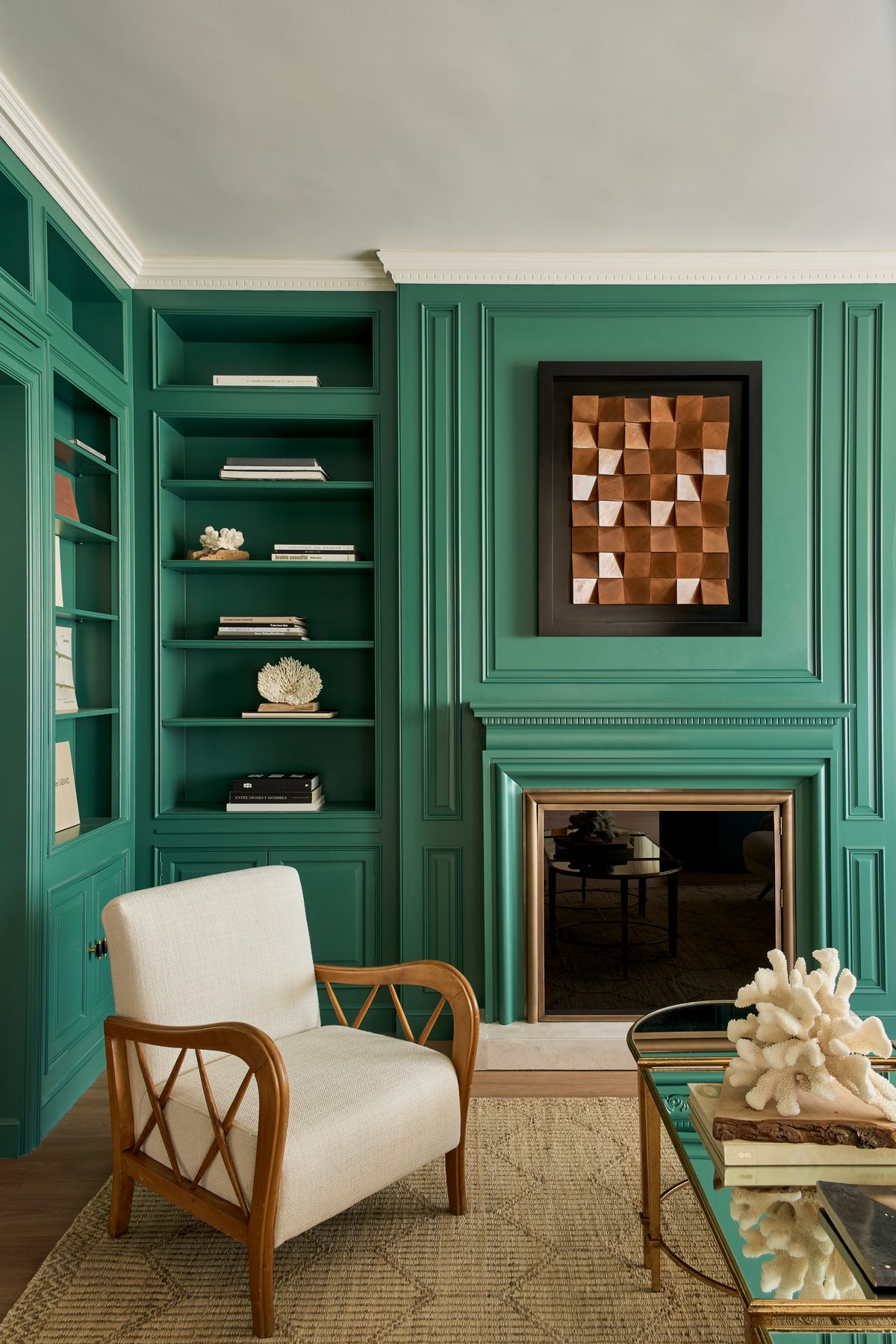 Salón verde con chimenea y butaca de madera