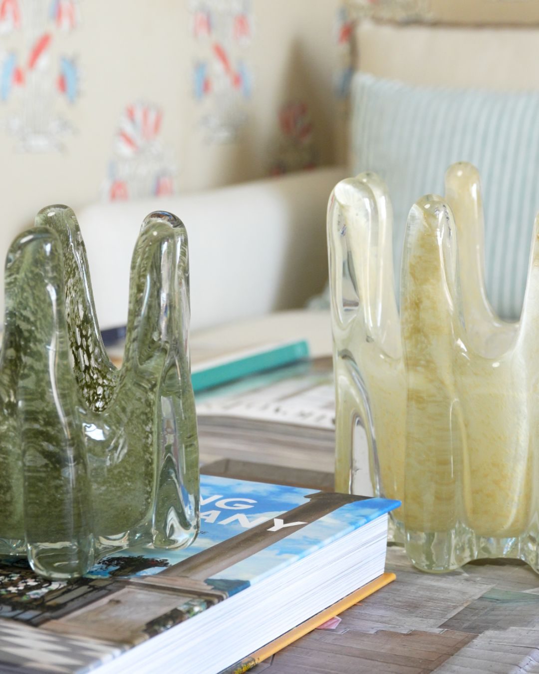 Jarrones de cristal verde sobre libros de interiorismo