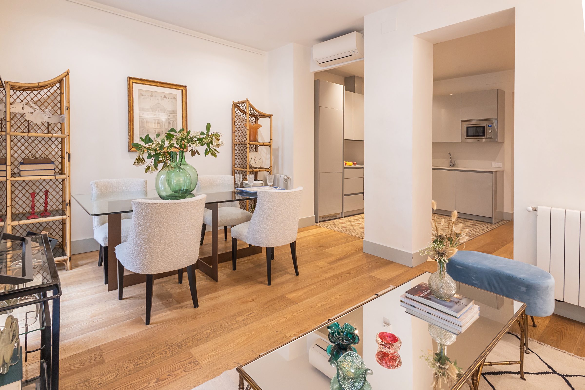 Salón comedor con estanterías de bambú y sillas tapizadas