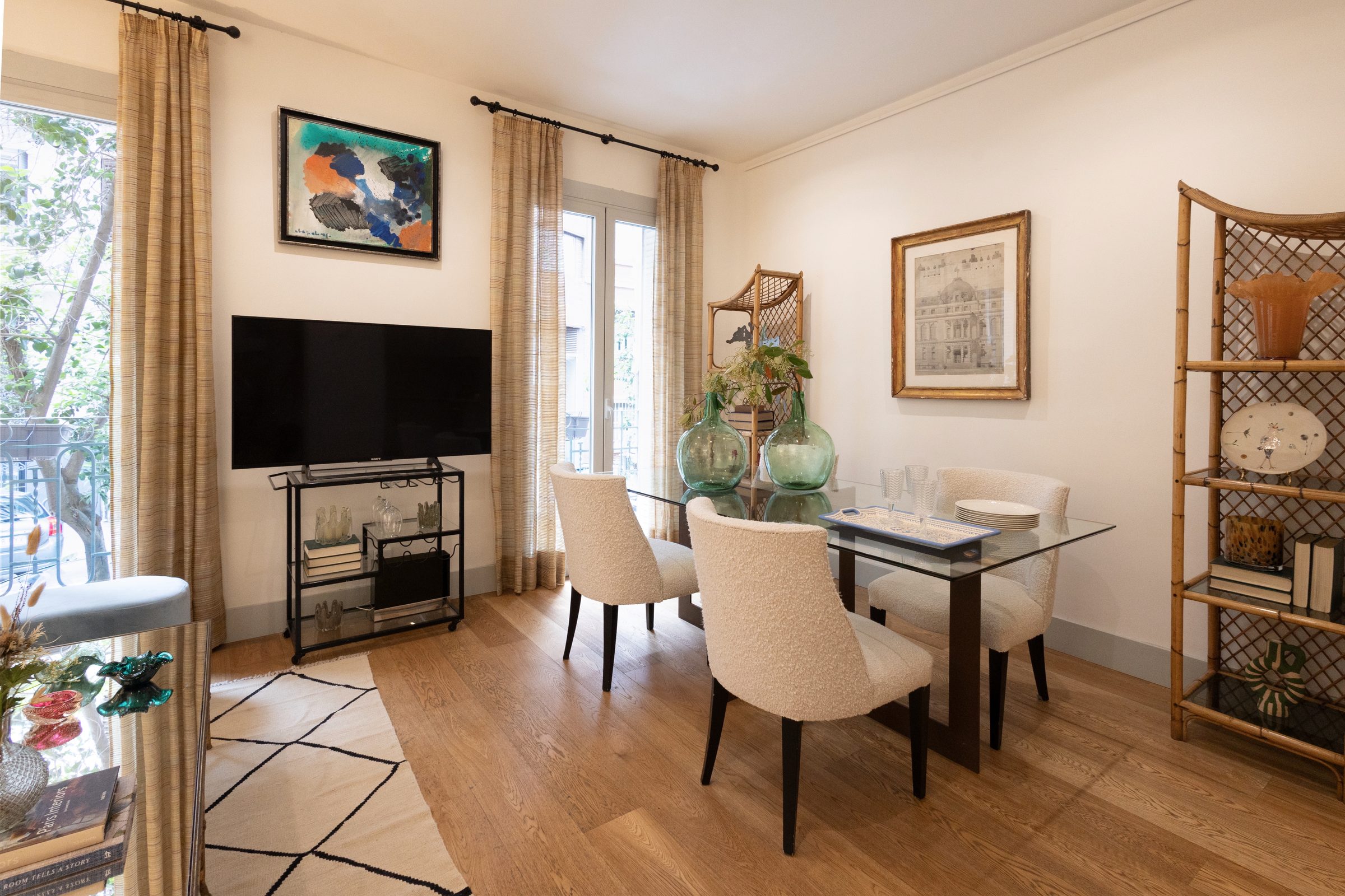 Salón con mesa de comedor de cristal y estantería de bambú